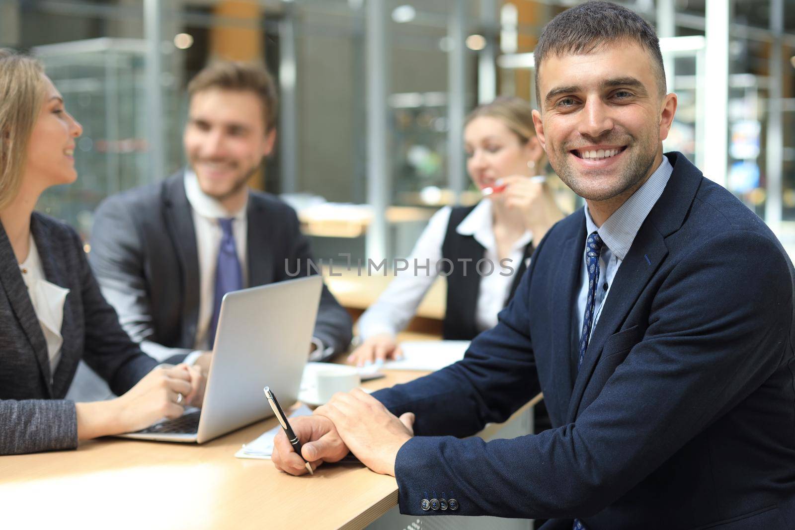 Businessman with colleagues in the background in office