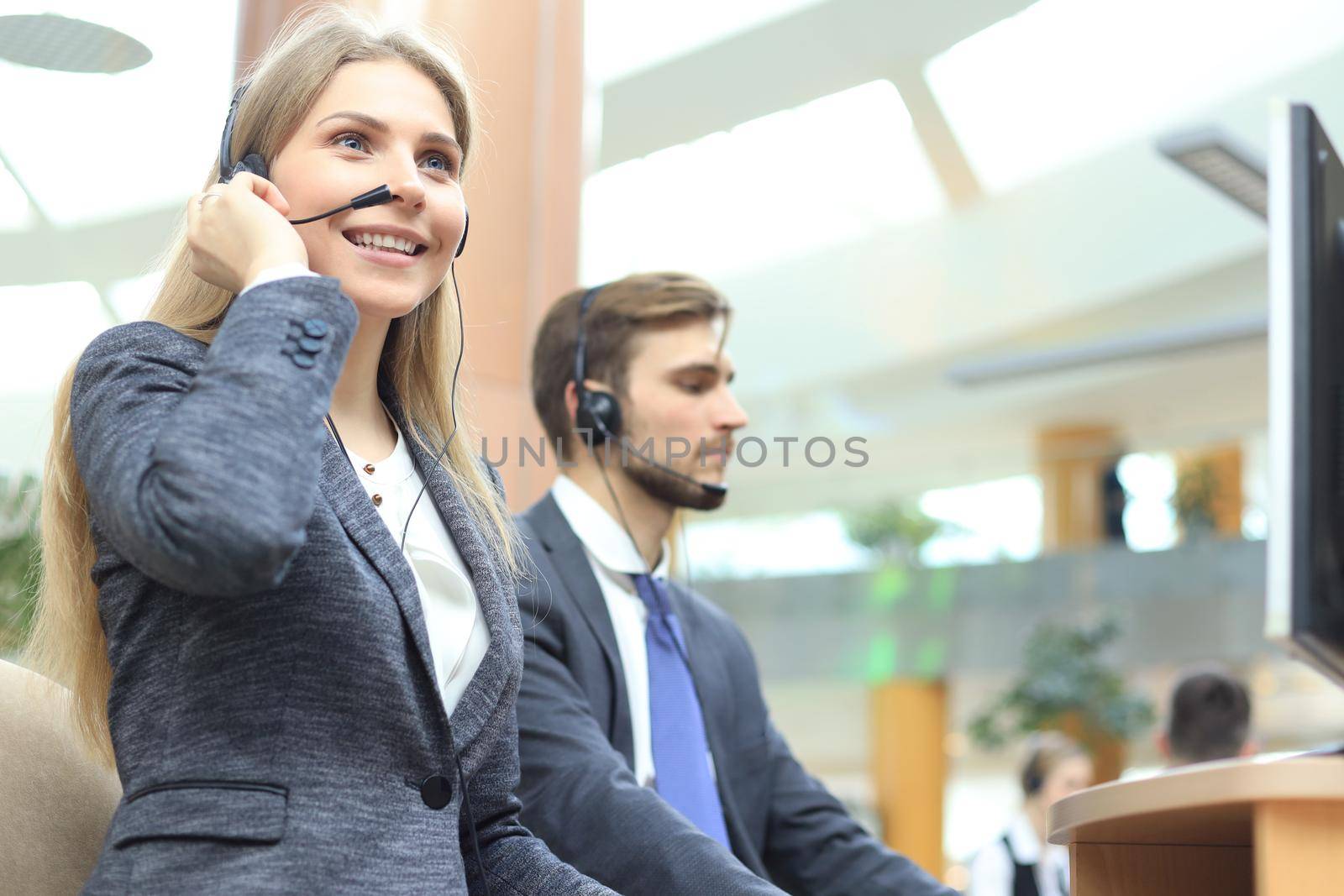 Female customer support operator with headset and smiling. by tsyhun