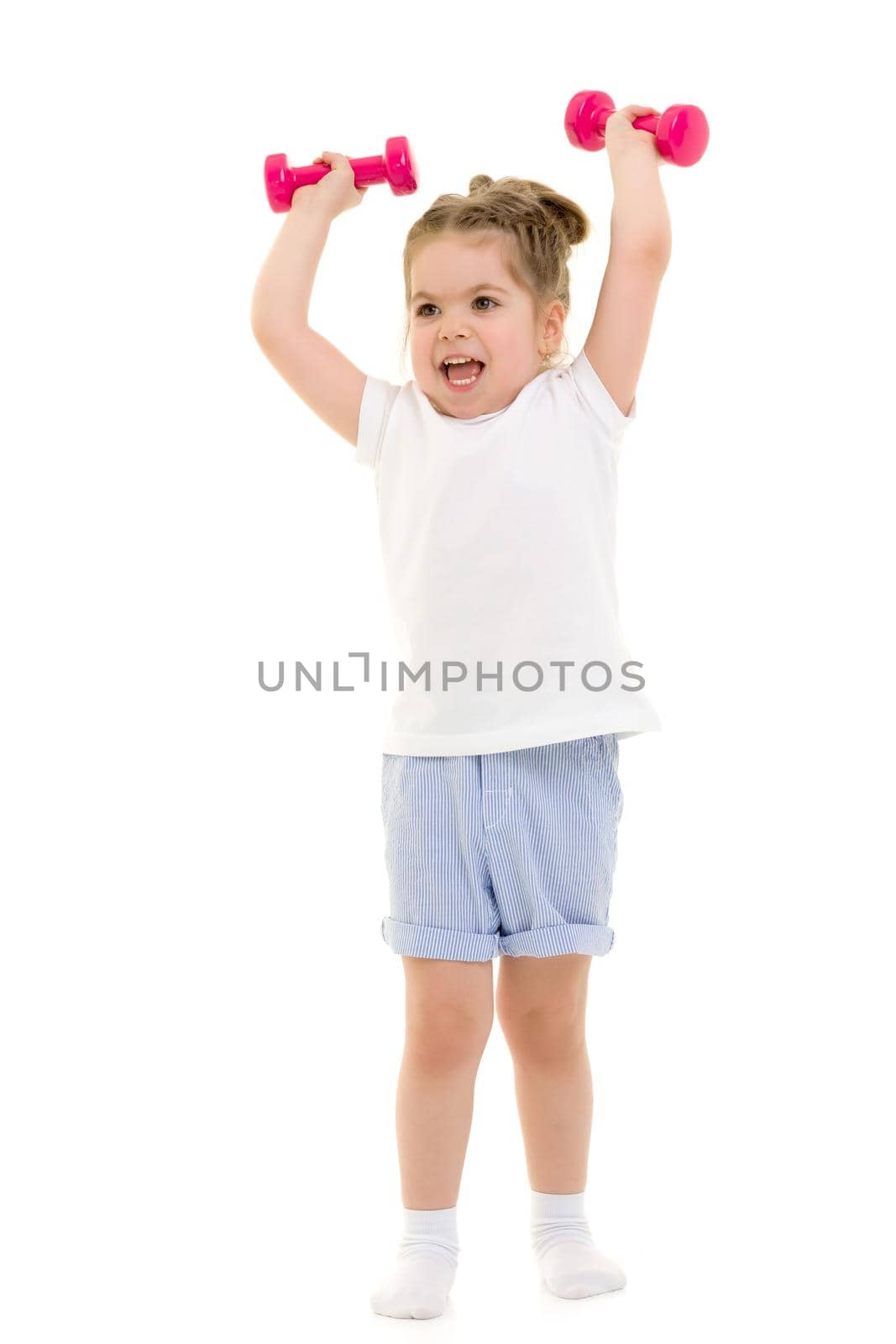 A cute little girl doing exercises with dumbbells. The concept of strength, health and sport. Isolated on white background.