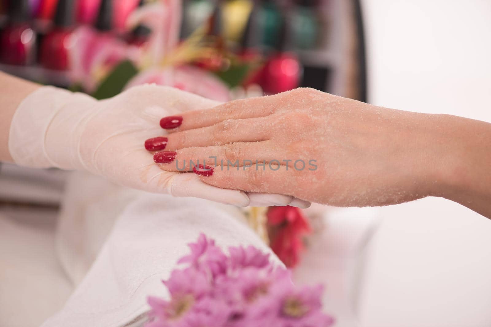 Woman hands receiving a manicure in beauty salon. Nail filing. Close up, selective focus.