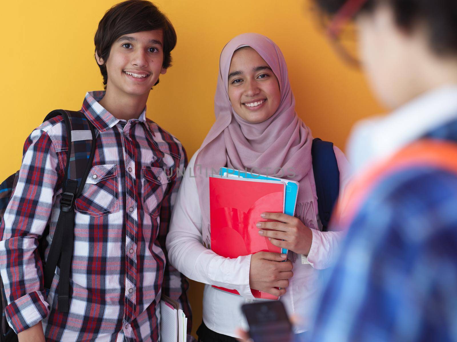 Arabic teenagers as team, students group working together on project using  laptop and tablet computer  online classroom  elearning education concept purple background