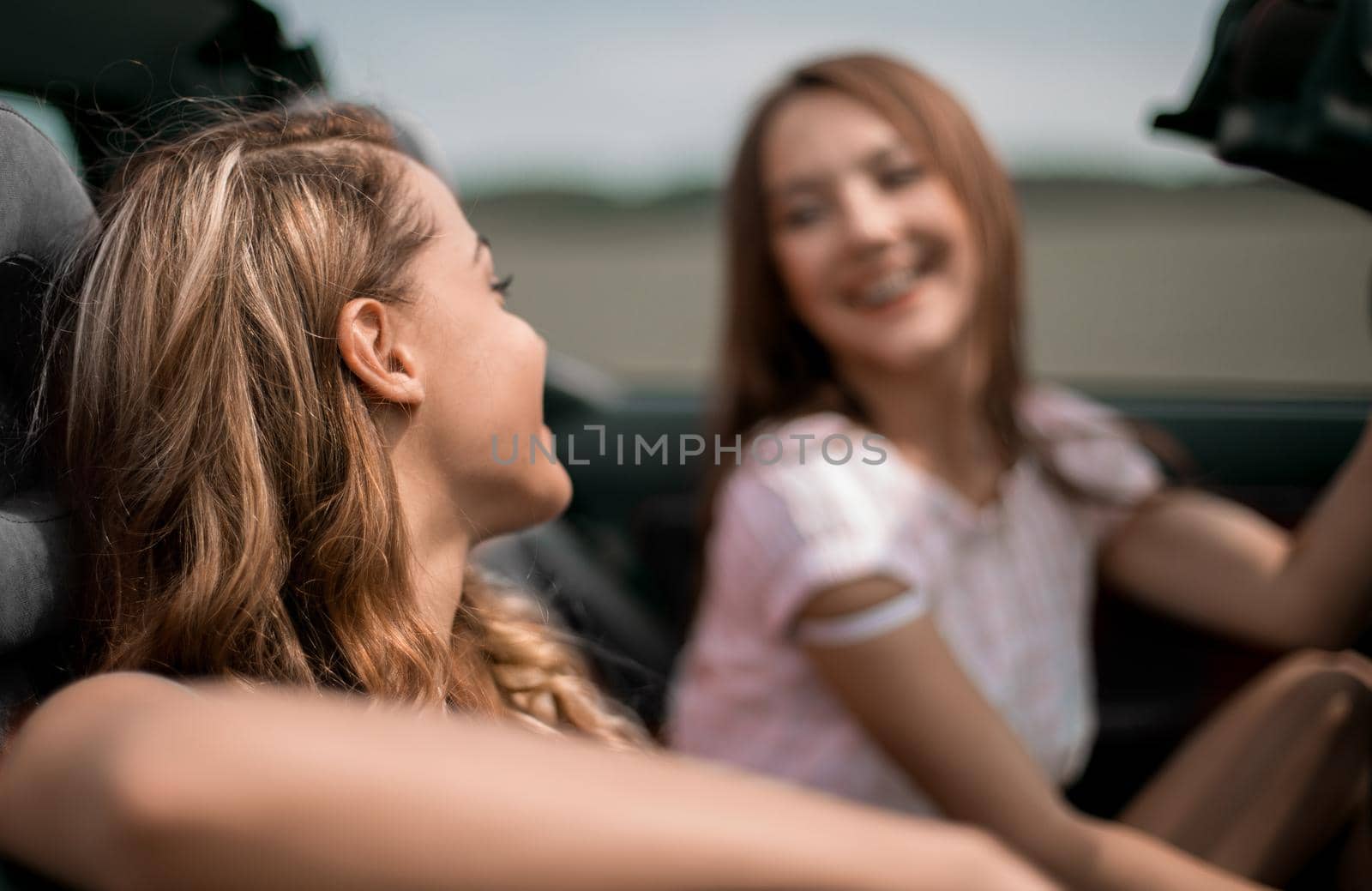 close up.attractive girlfriends traveling in a car on a summer day
