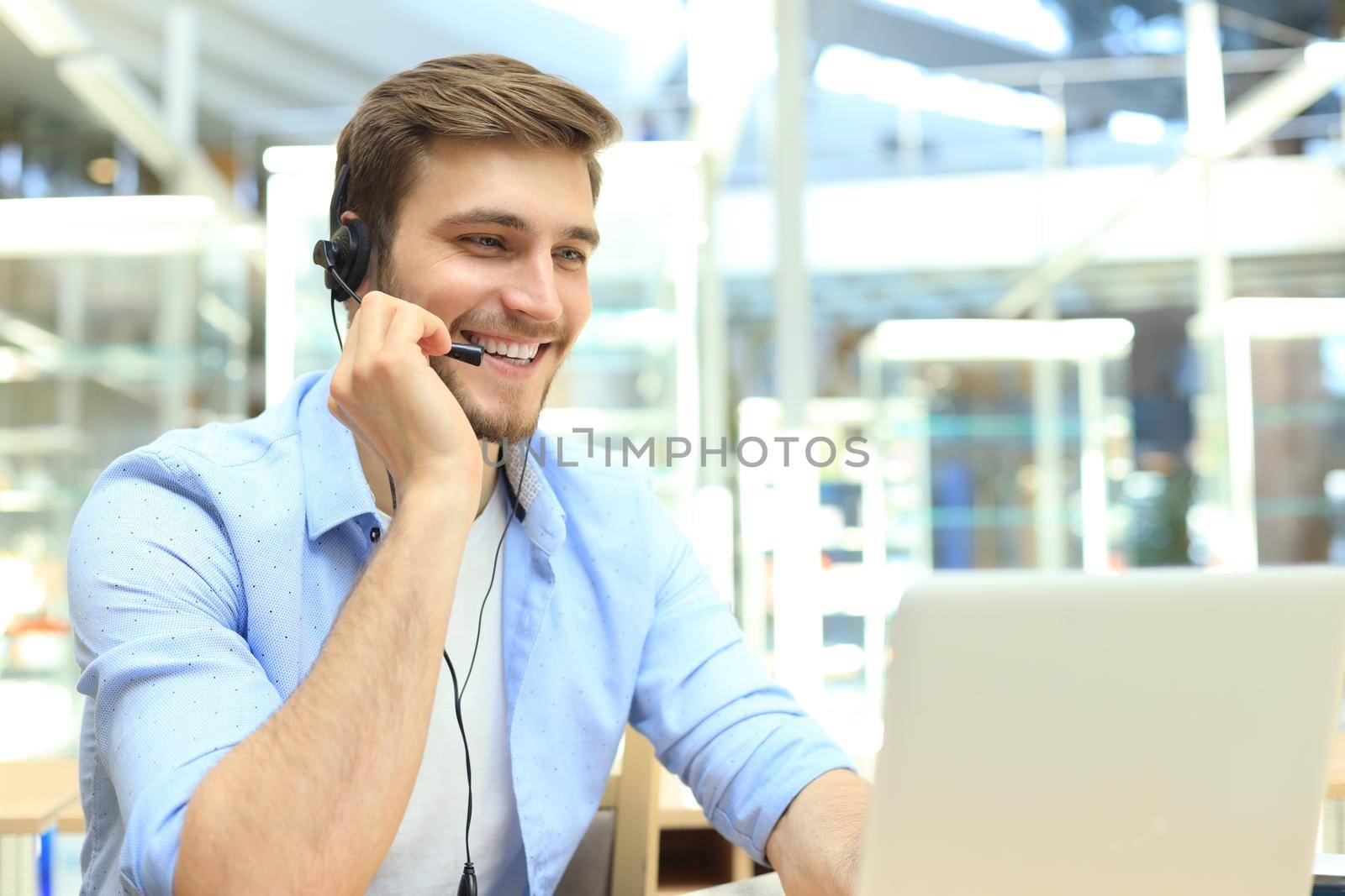 Happy young male customer support executive working in office