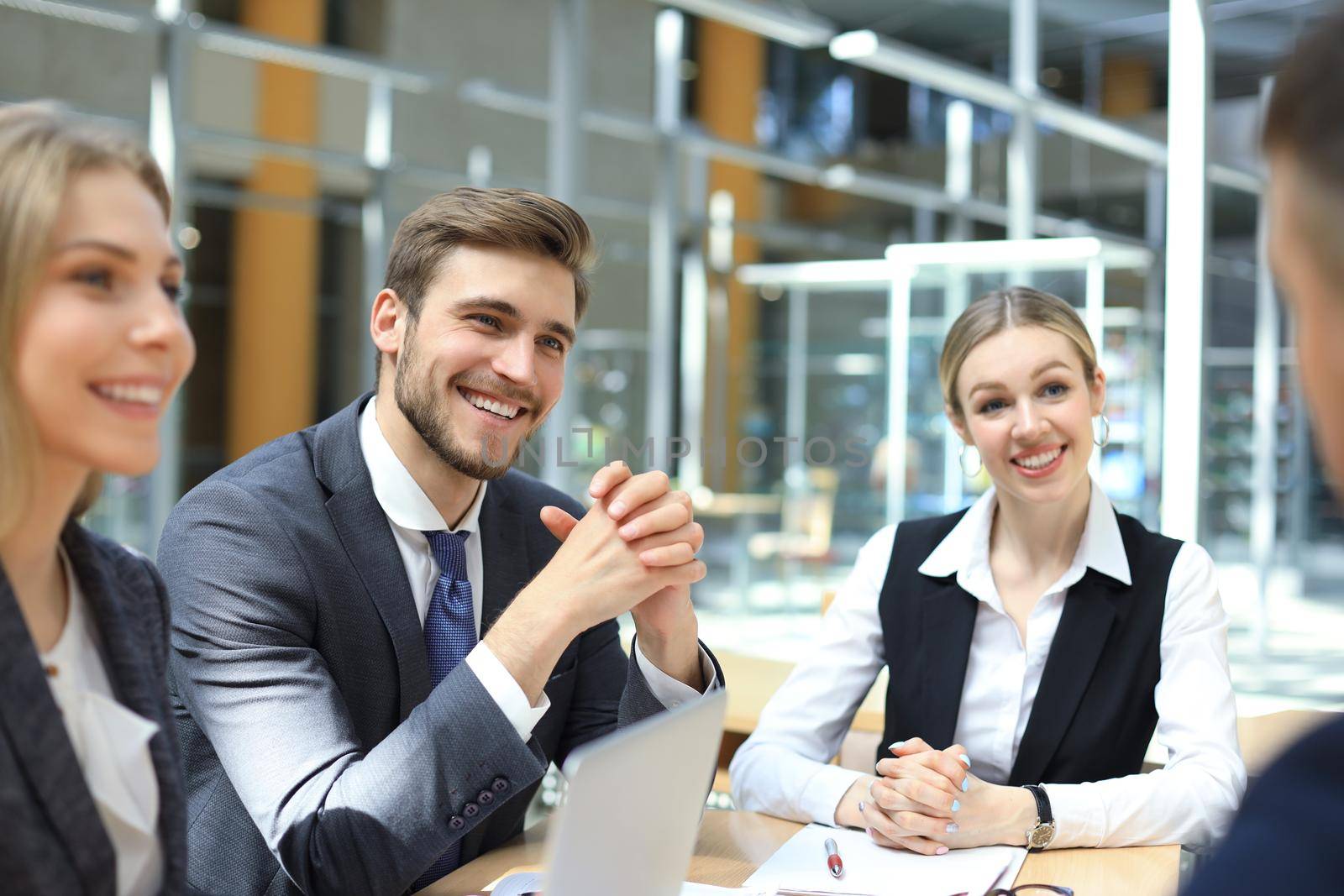 Startup business team on meeting in modern bright office interior and working on laptop