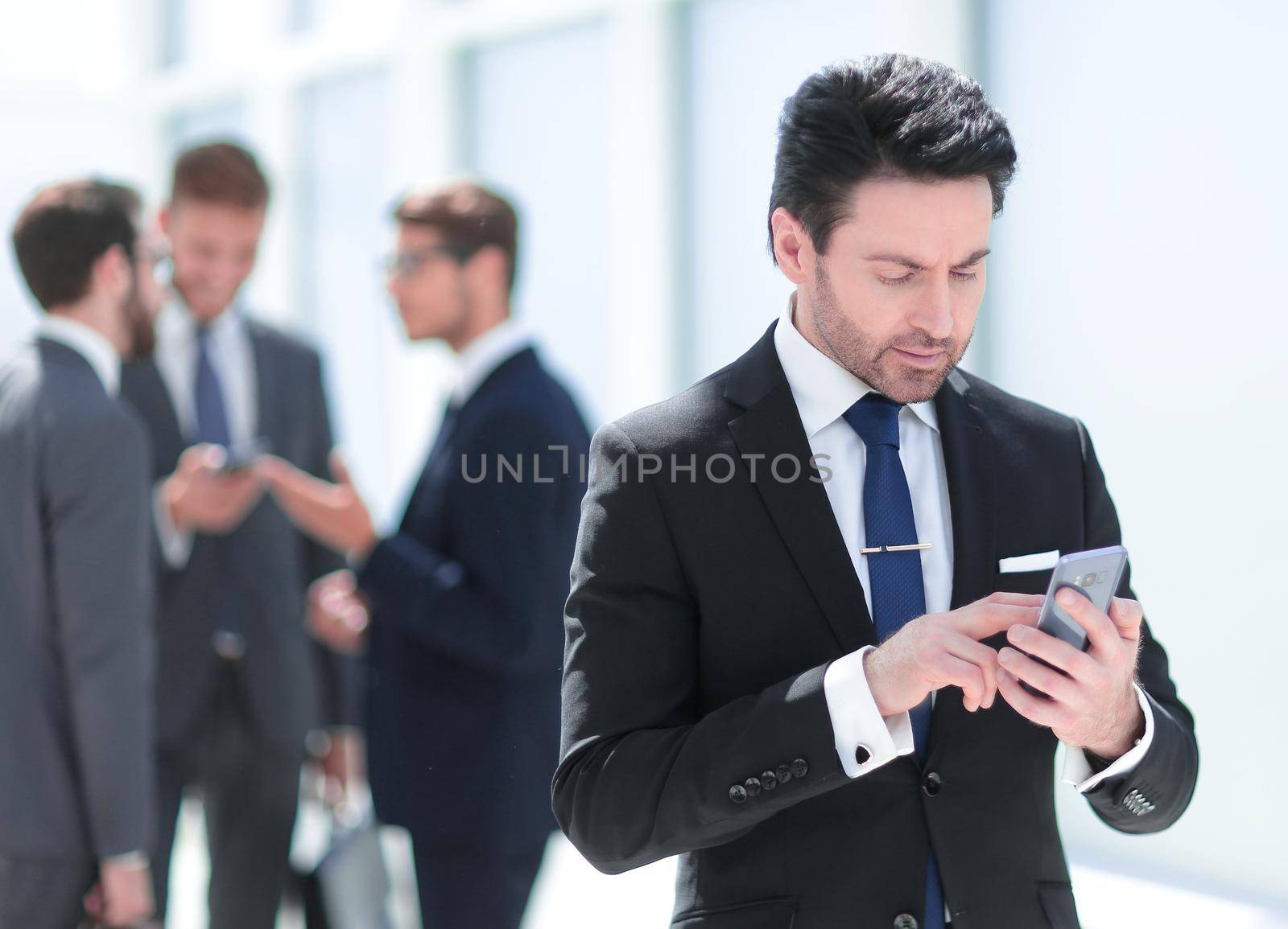 businessman looking at the smartphone screen by asdf