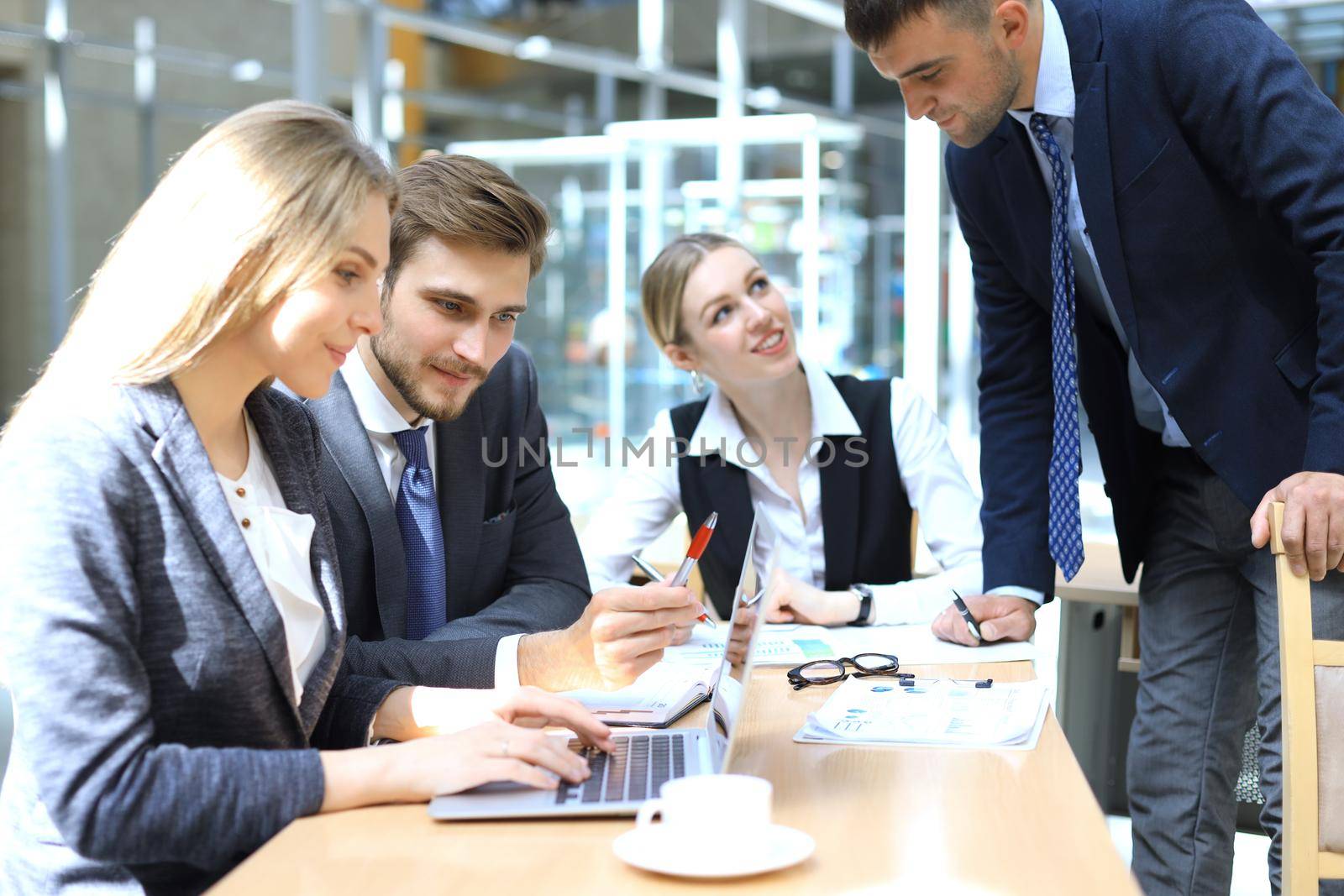 Startup business team on meeting in modern bright office interior and working on laptop