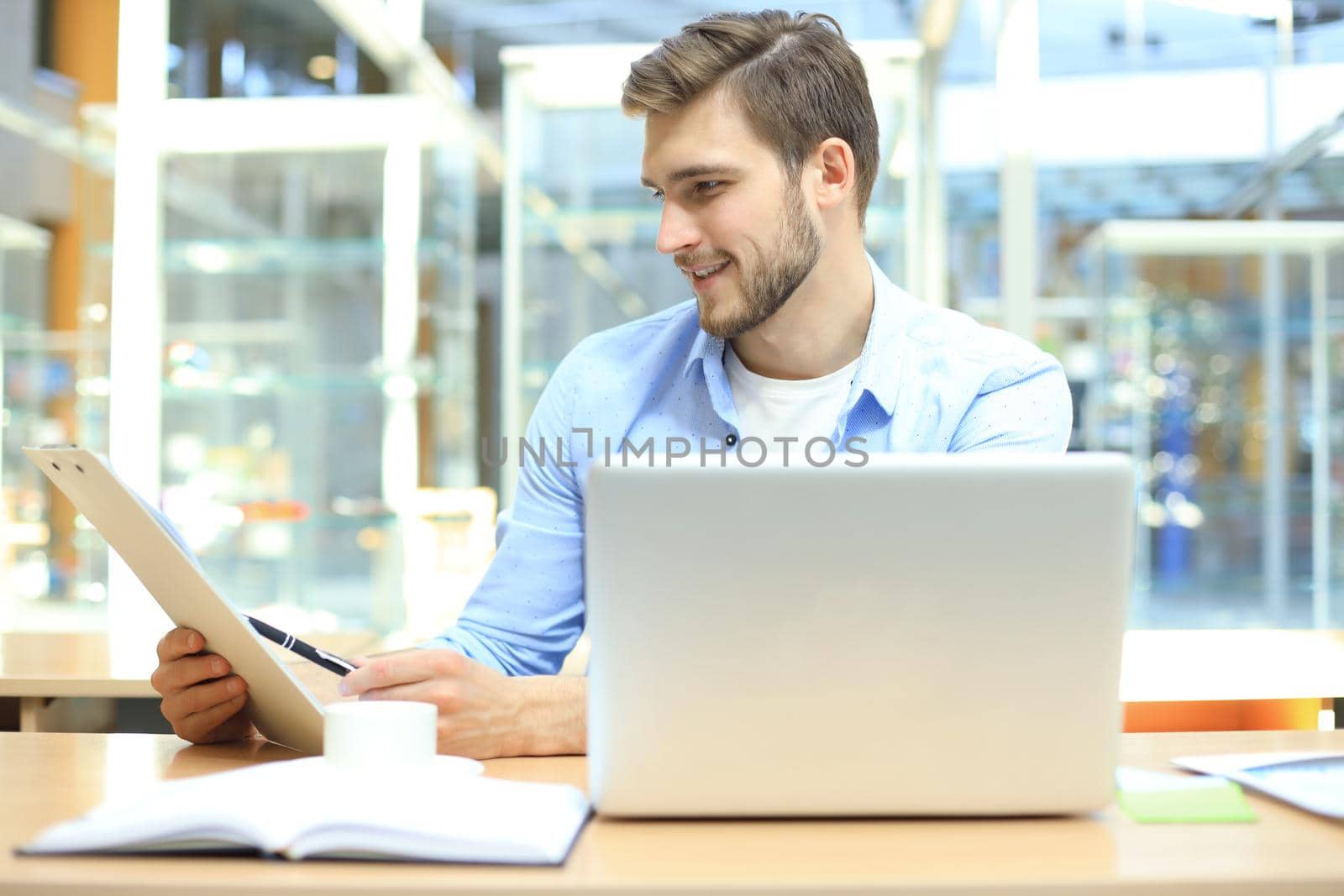 Portrait of young man sitting at his desk in the office