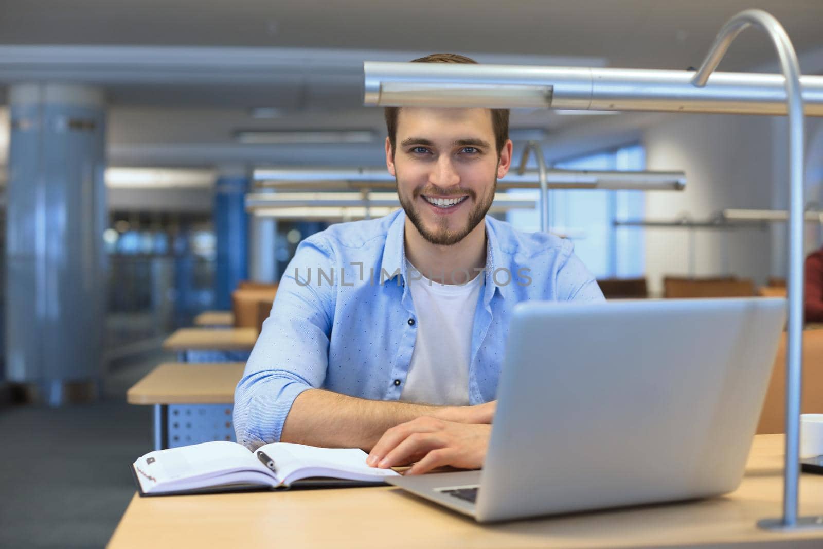 Portrait of young man sitting at his desk in the office