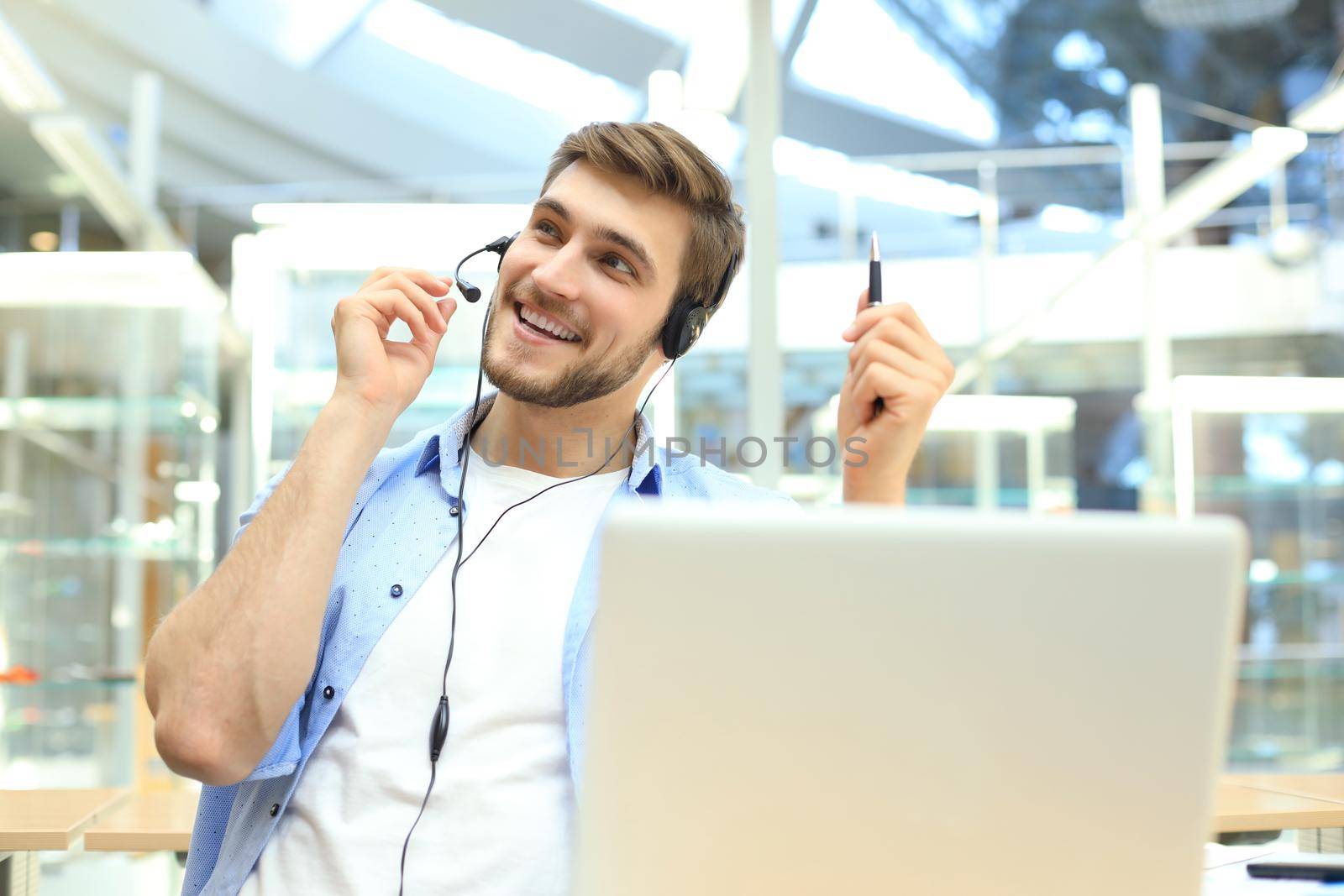 Happy young male customer support executive working in office