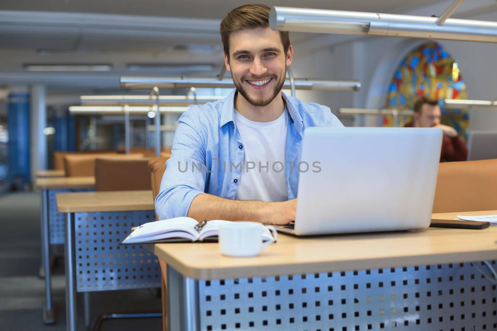 Young student working on laptop in library