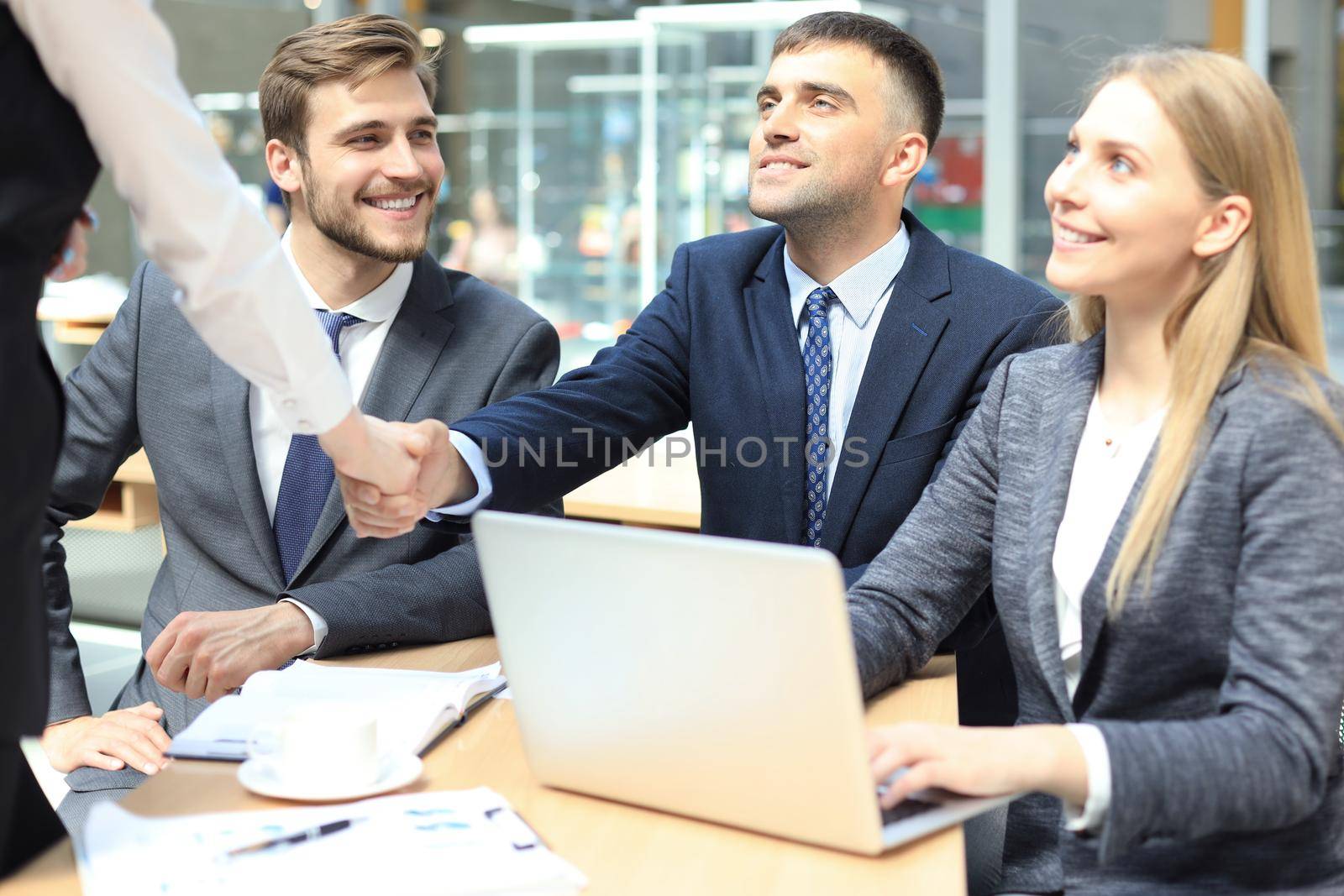 Welcome to our team. Young modern businessmen shaking hands while working in the creative office