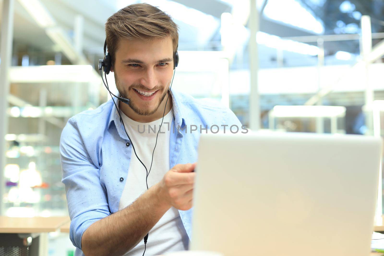 Smiling friendly handsome young male call centre operator