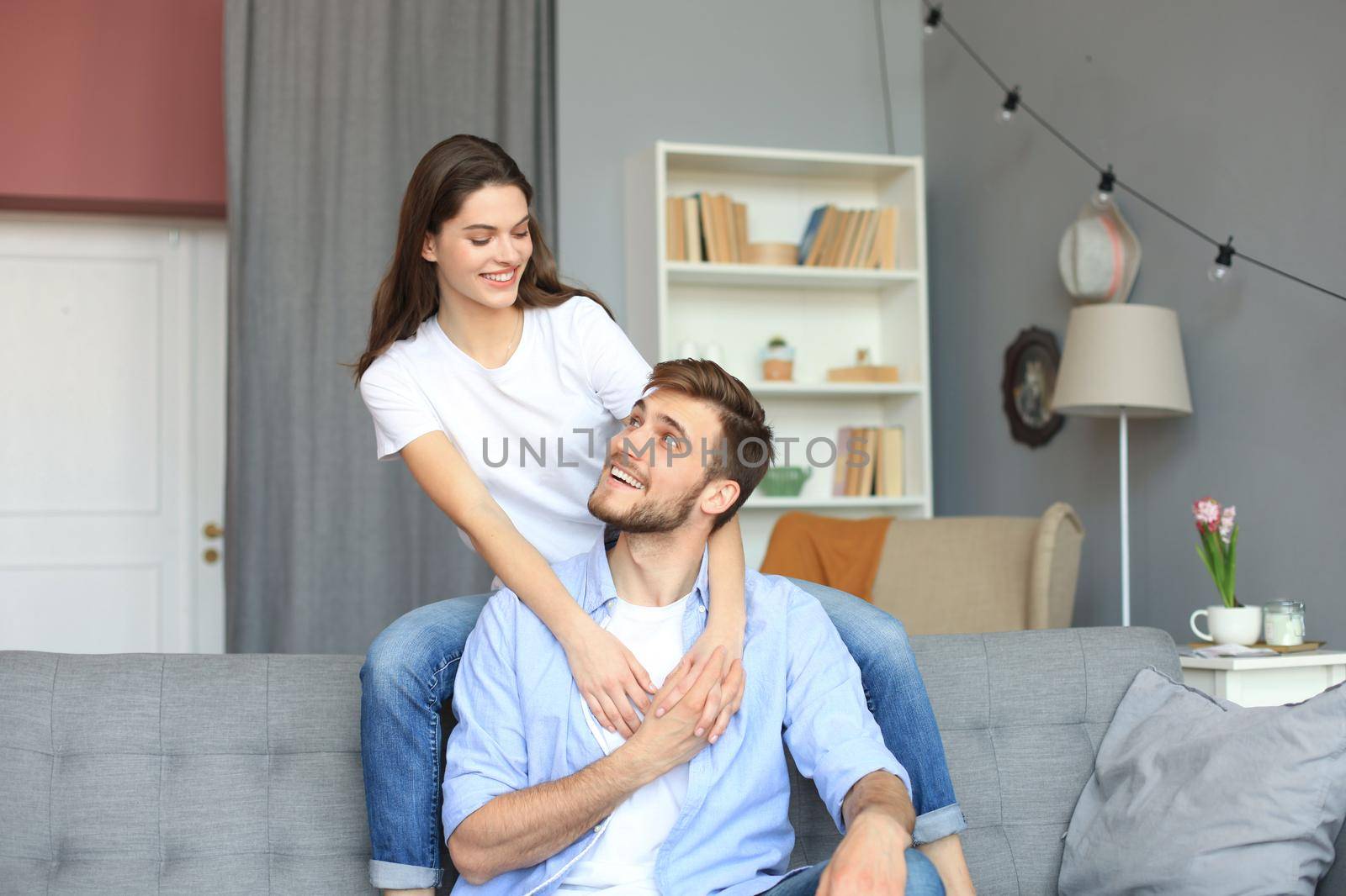 Beautiful woman with boyfriend spending quality time together on sofa at home in the living room. by tsyhun