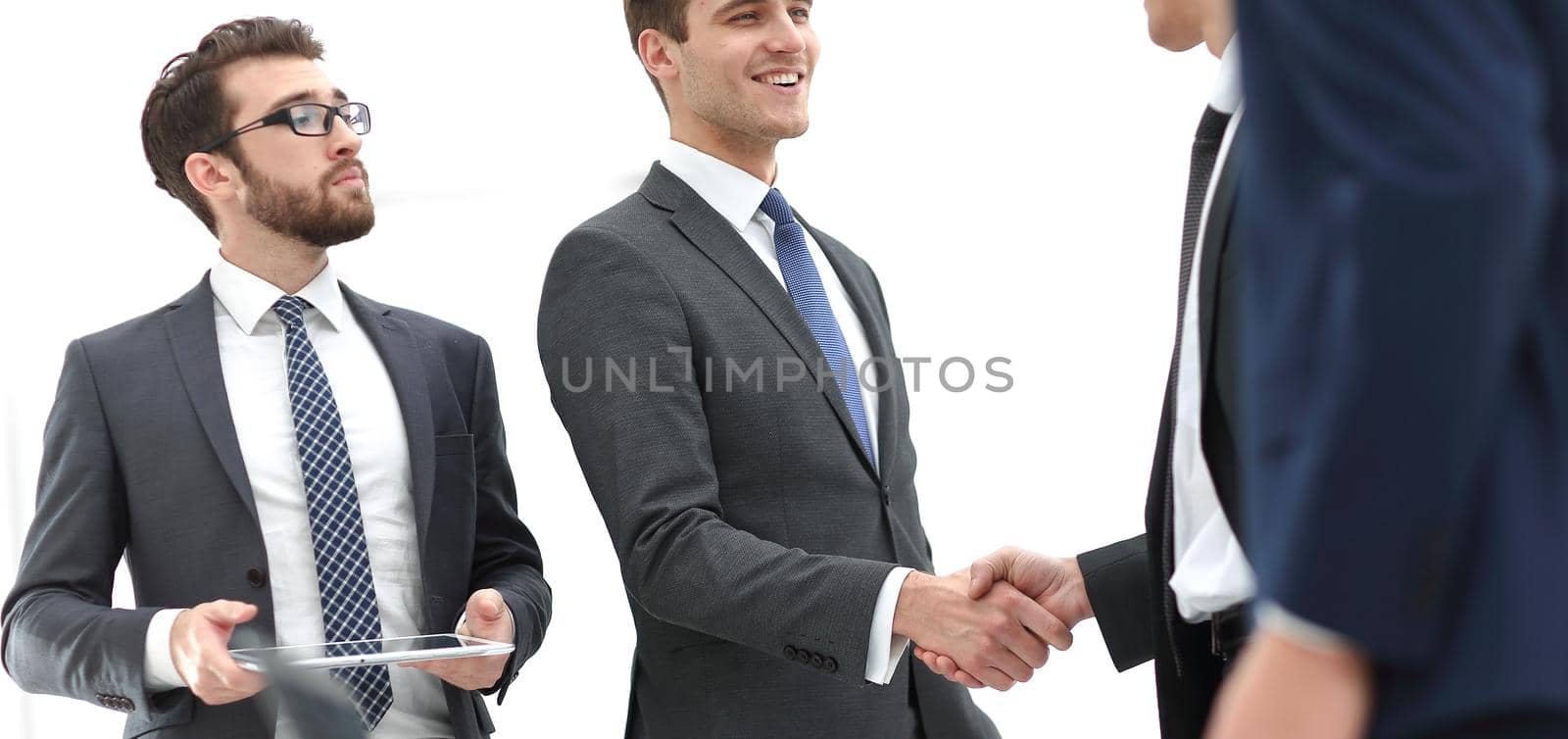 Business associates shaking hands in office.