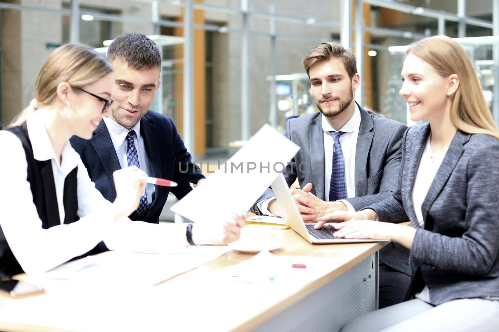 Group of business partners discussing ideas and planning work in office. by tsyhun