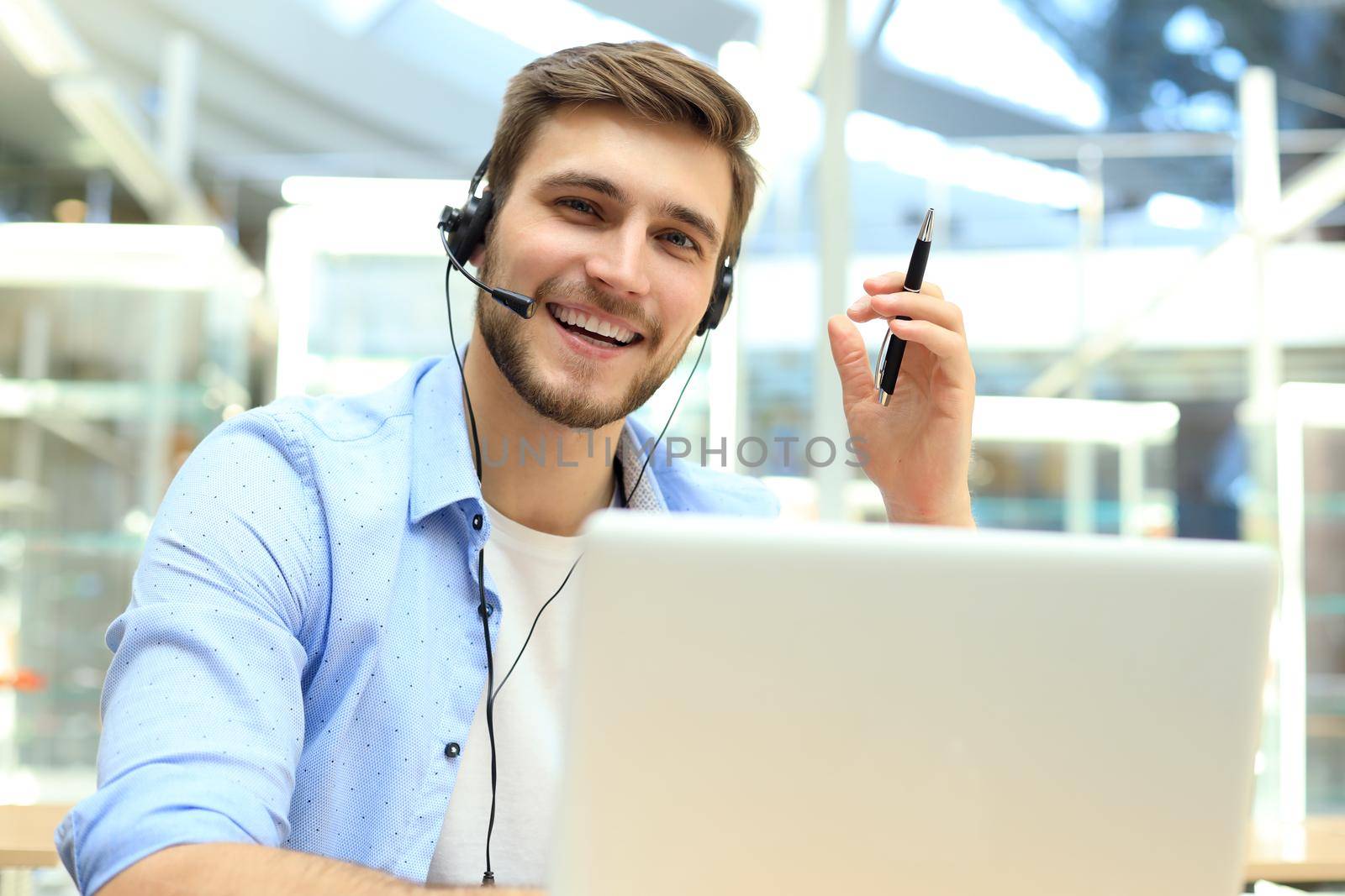 Happy young male customer support executive working in office