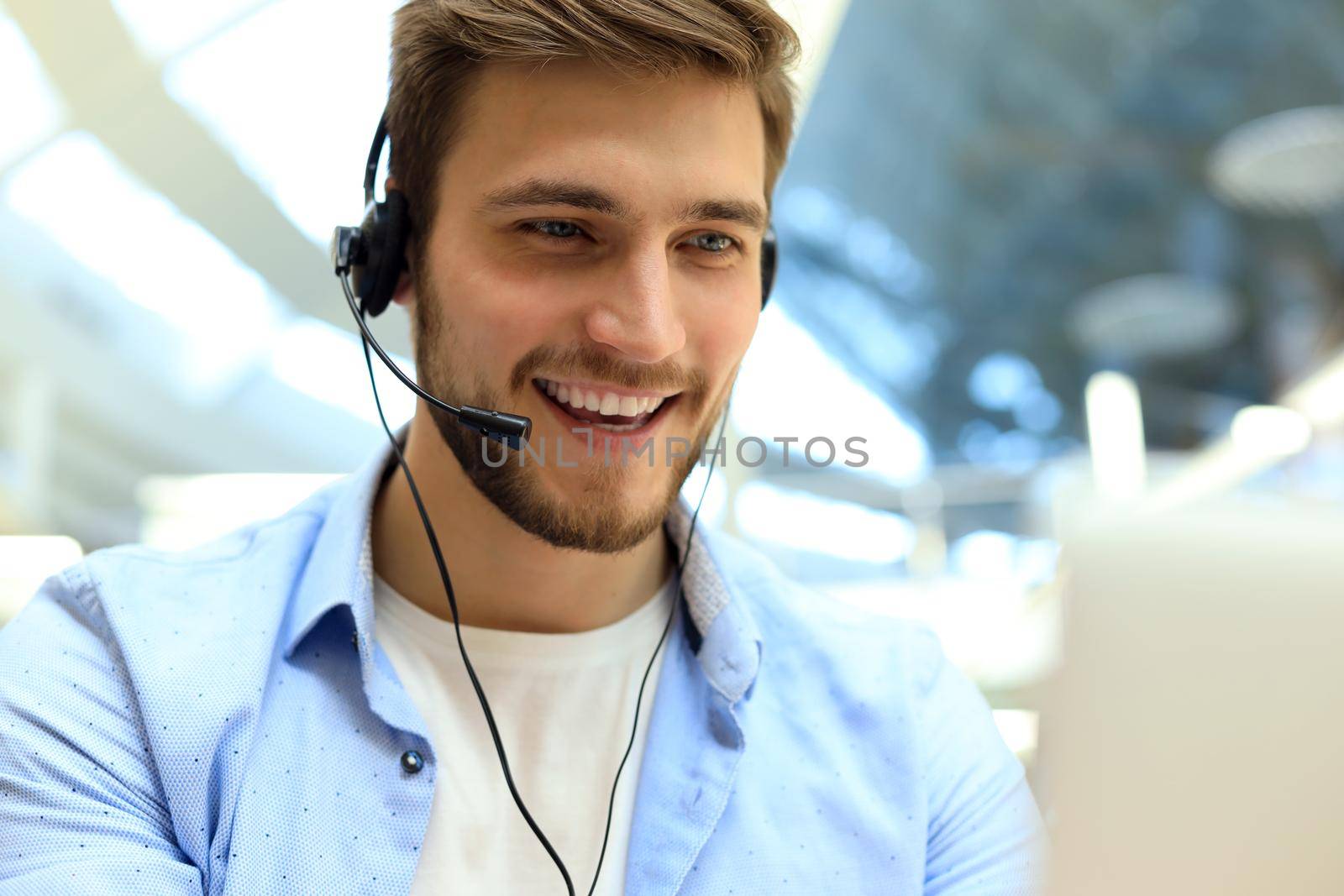 Smiling friendly handsome young male call centre operator