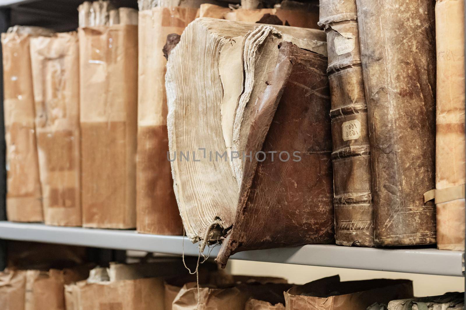 Old worn 17th century books on a shelf in the library's archives