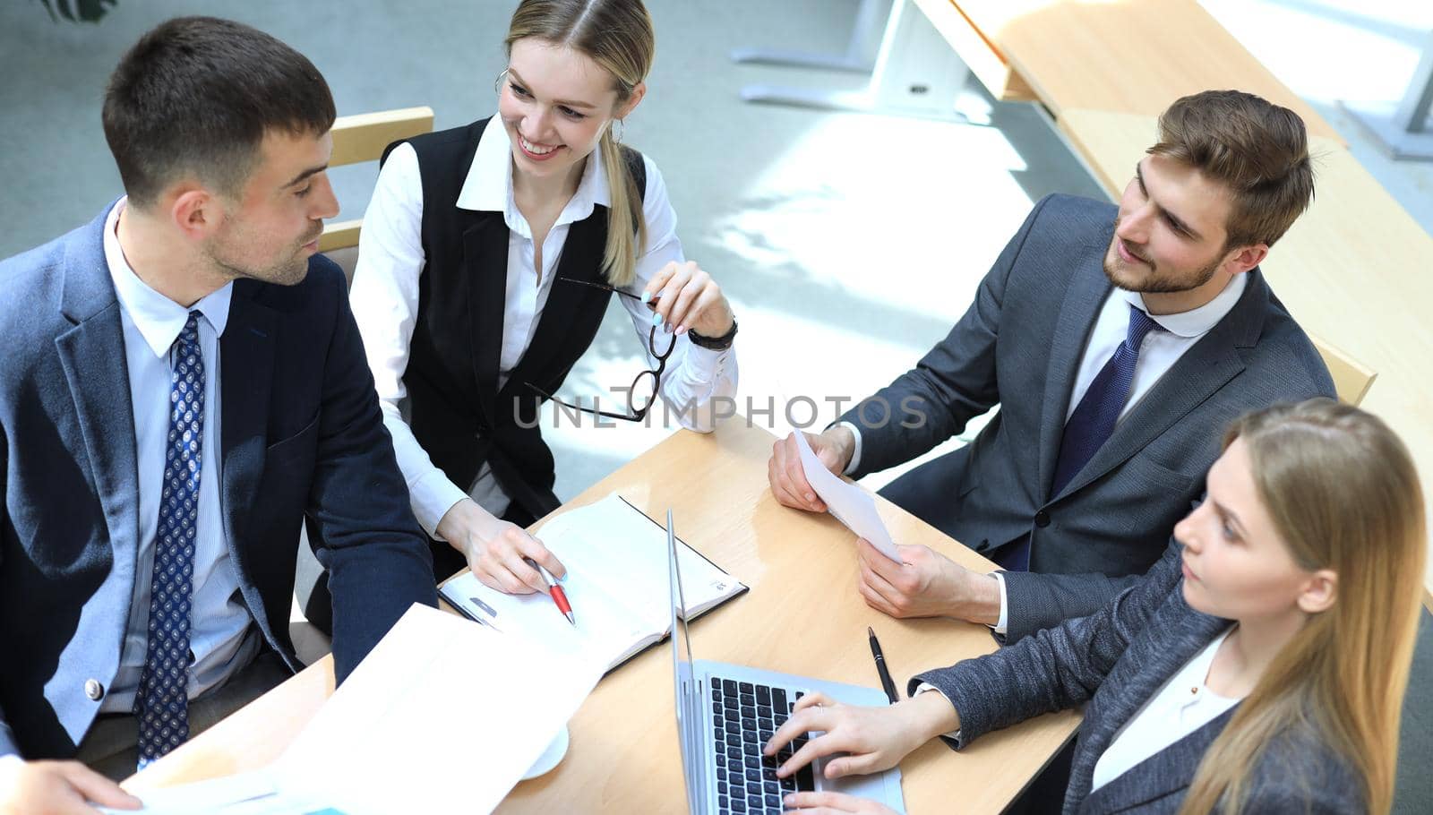 Top view of buiness team brainstorming while sitting at the office table together