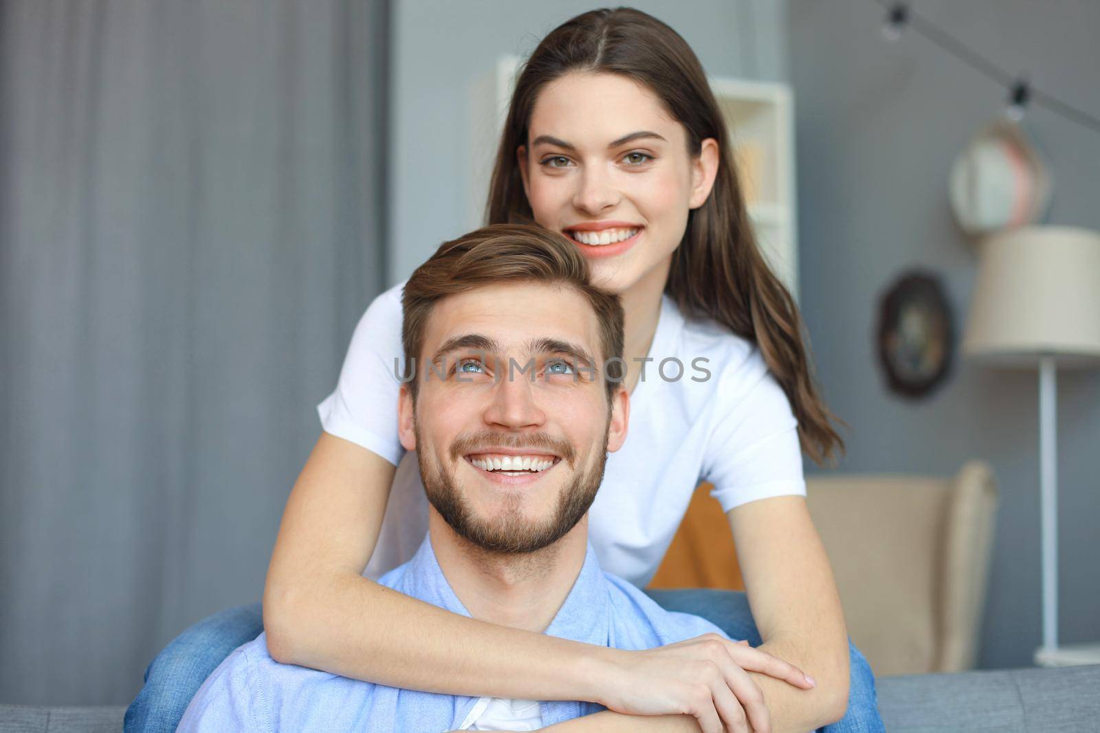 Beautiful woman with boyfriend spending quality time together on sofa at home in the living room