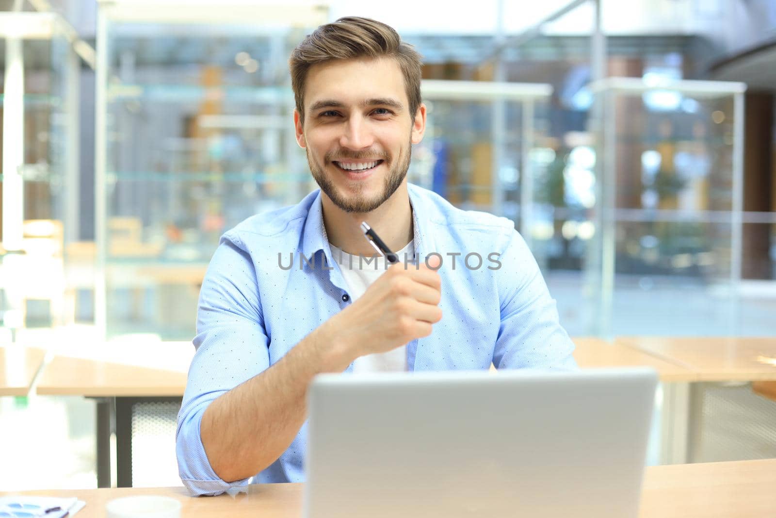 Portrait of young man sitting at his desk in the office