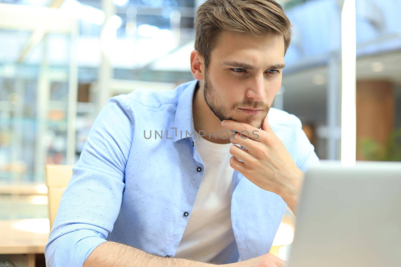 Portrait of young man sitting at his desk in the office. by tsyhun