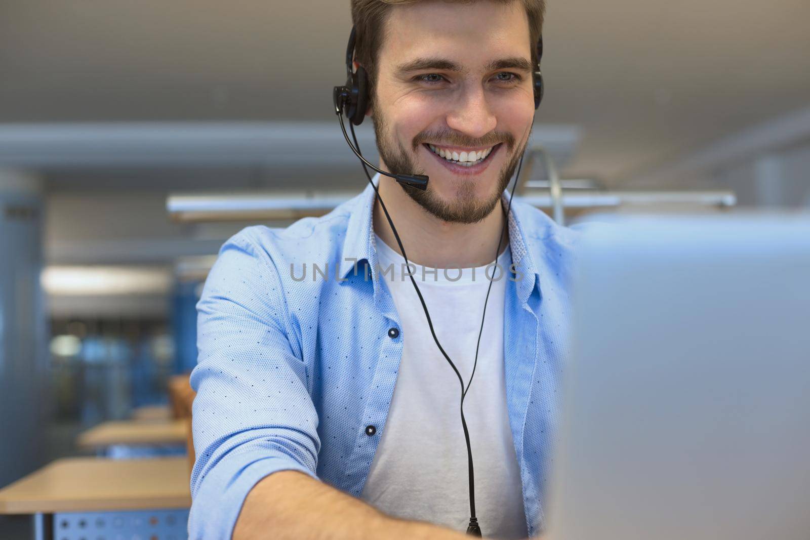 Happy young male customer support executive working in office