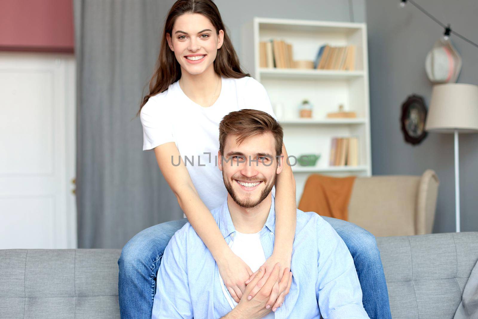 Beautiful woman with boyfriend spending quality time together on sofa at home in the living room. by tsyhun