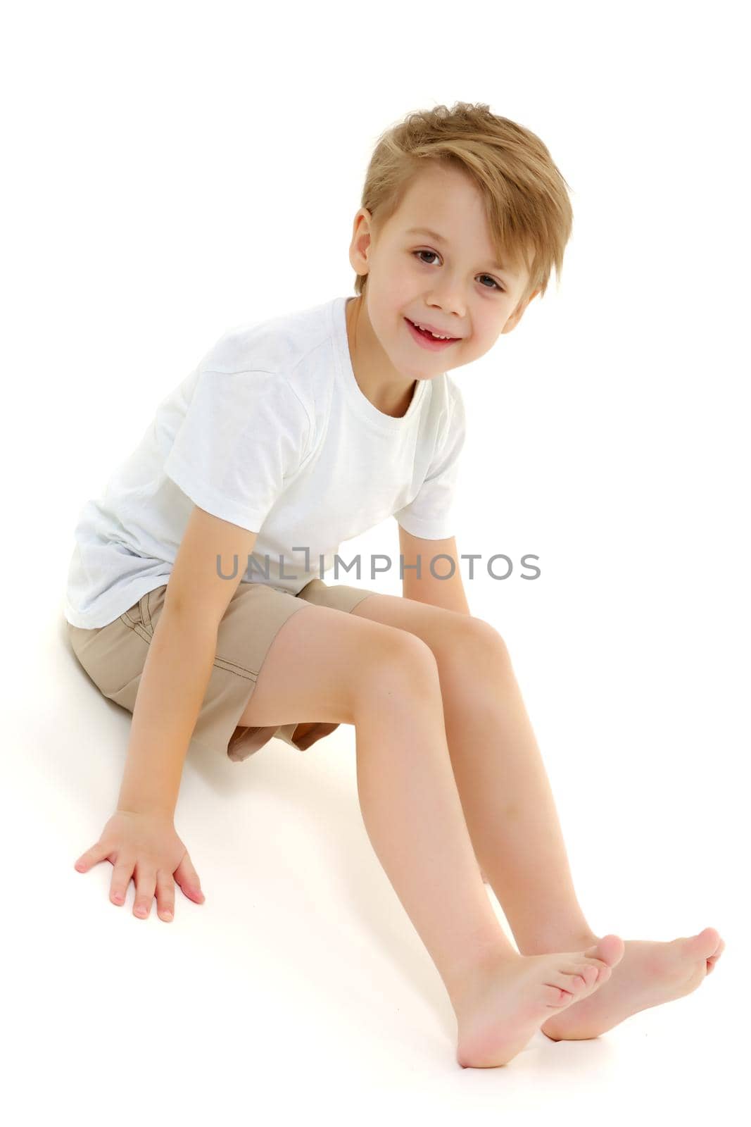 A little boy in a pure white t-shirt laughs. Emotions. by kolesnikov_studio