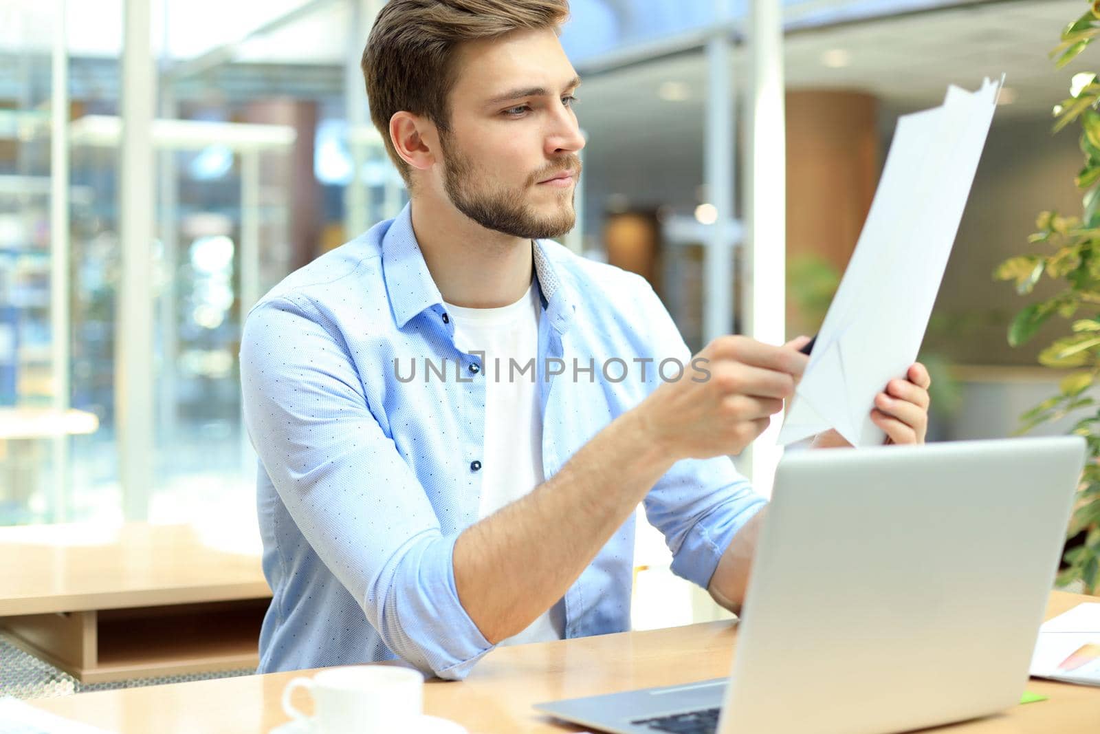 Portrait of young man sitting at his desk in the office. by tsyhun