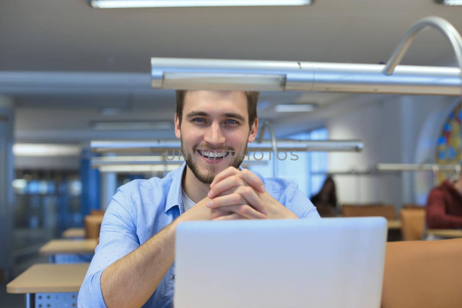 Portrait of young man sitting at his desk in the office