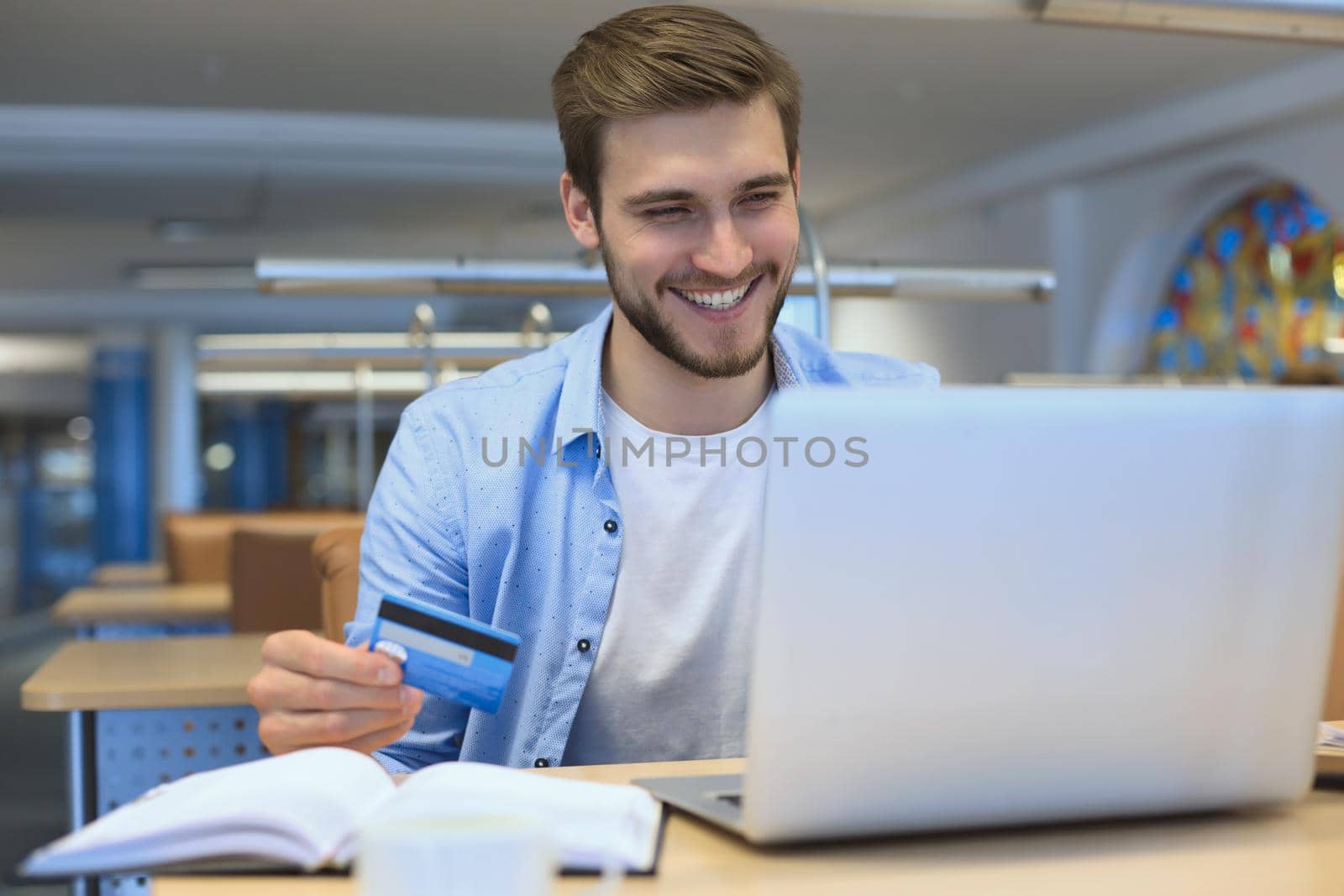 Portrait of young man sitting at his desk in the office. by tsyhun