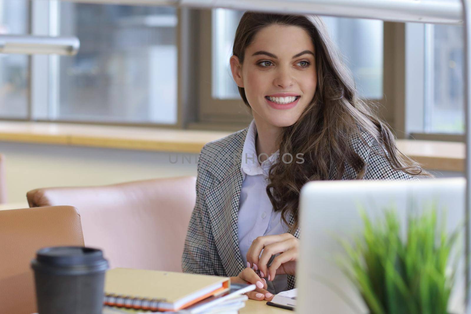 Portrait of a pretty female student with laptop in library