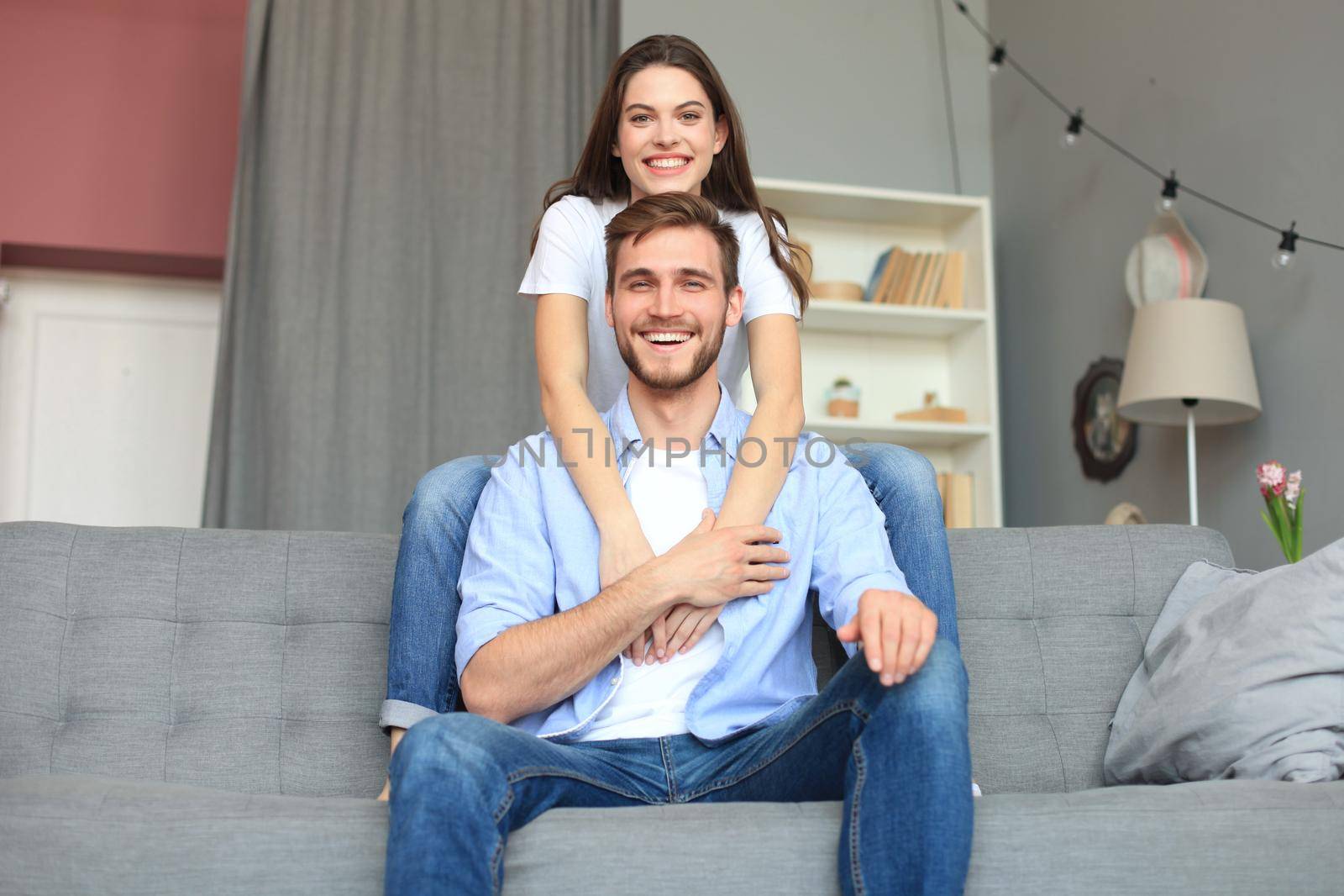 Beautiful woman with boyfriend spending quality time together on sofa at home in the living room. by tsyhun