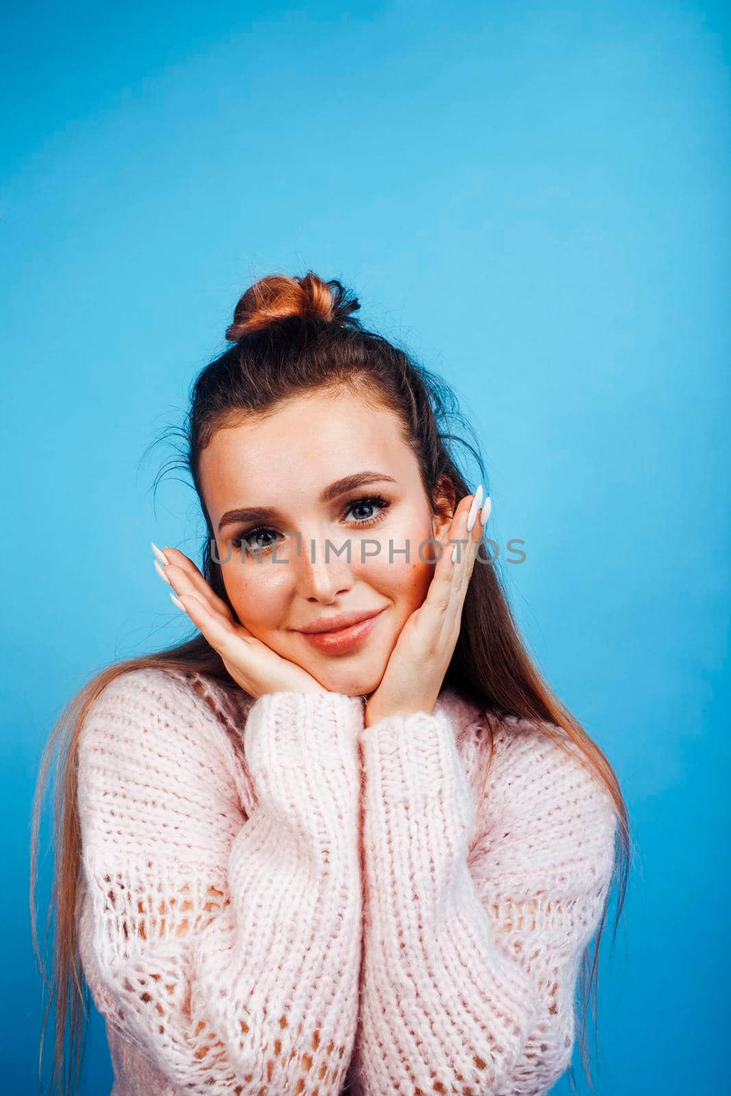 young pretty modern hipster girl posing emotional happy on blue background, lifestyle people concept close up