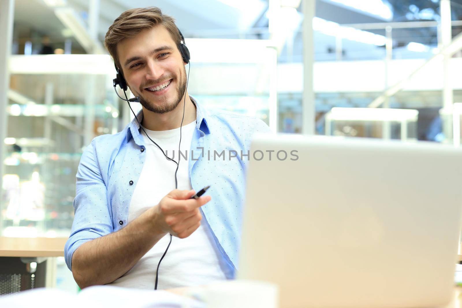 Smiling friendly handsome young male call centre operator. by tsyhun