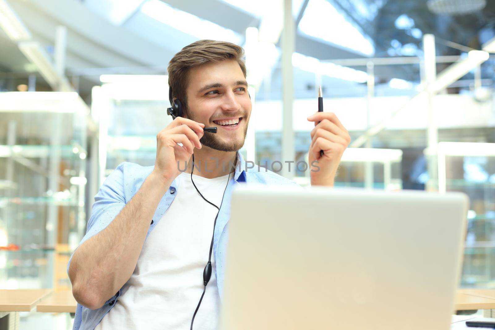 Smiling friendly handsome young male call centre operator. by tsyhun