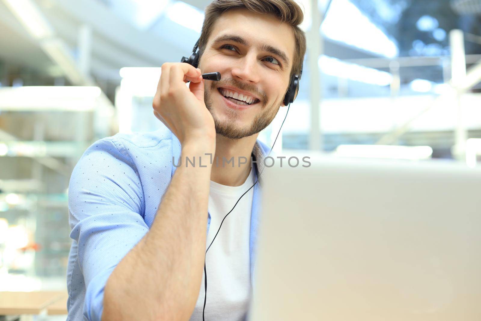 Happy young male customer support executive working in office