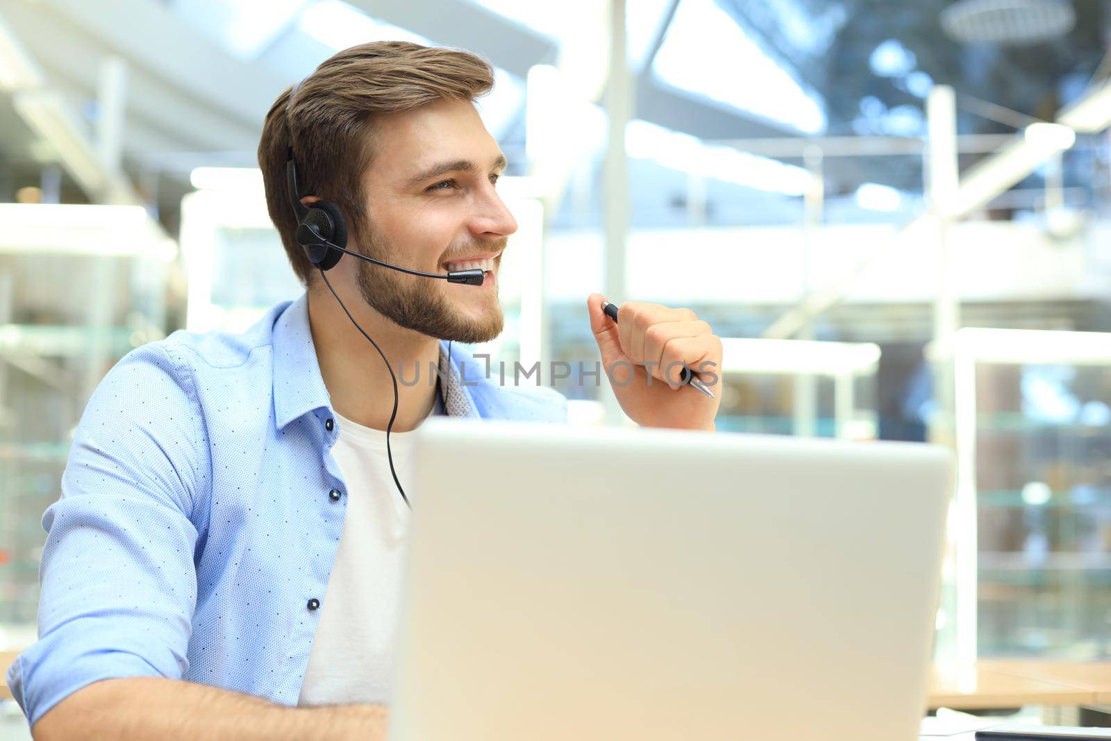 Happy young male customer support executive working in office