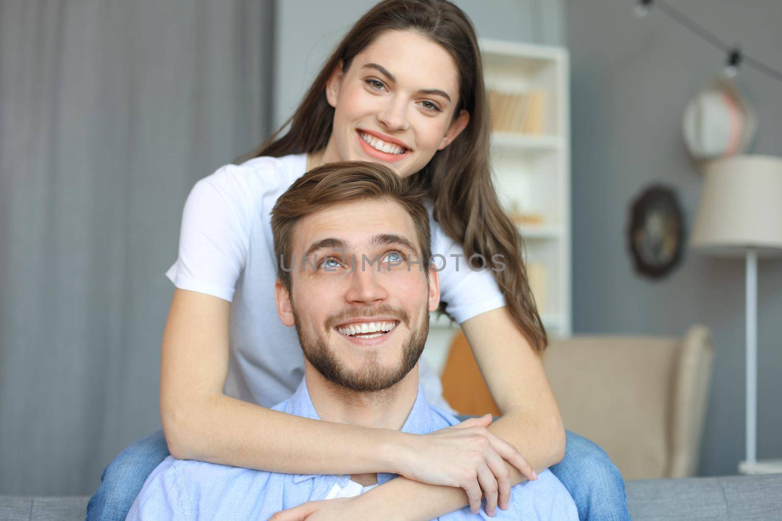 Beautiful woman with boyfriend spending quality time together on sofa at home in the living room. by tsyhun