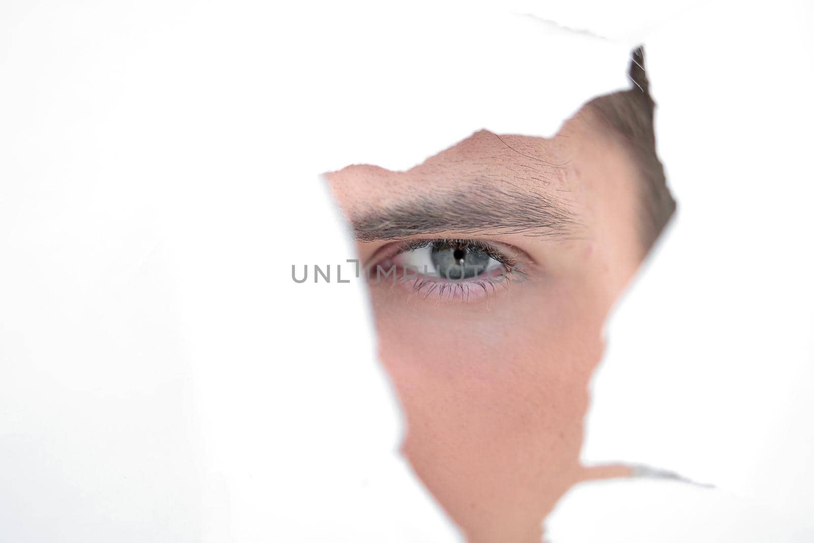 close up. businessman looking through a hole in the paper wall.photo with copy space