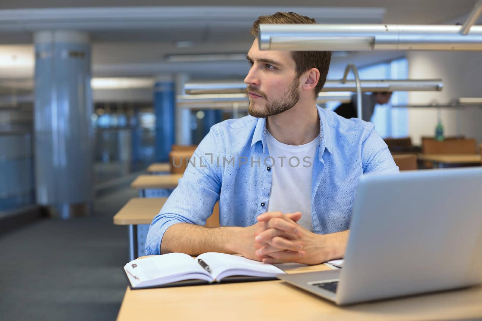 Portrait of young man sitting at his desk in the office