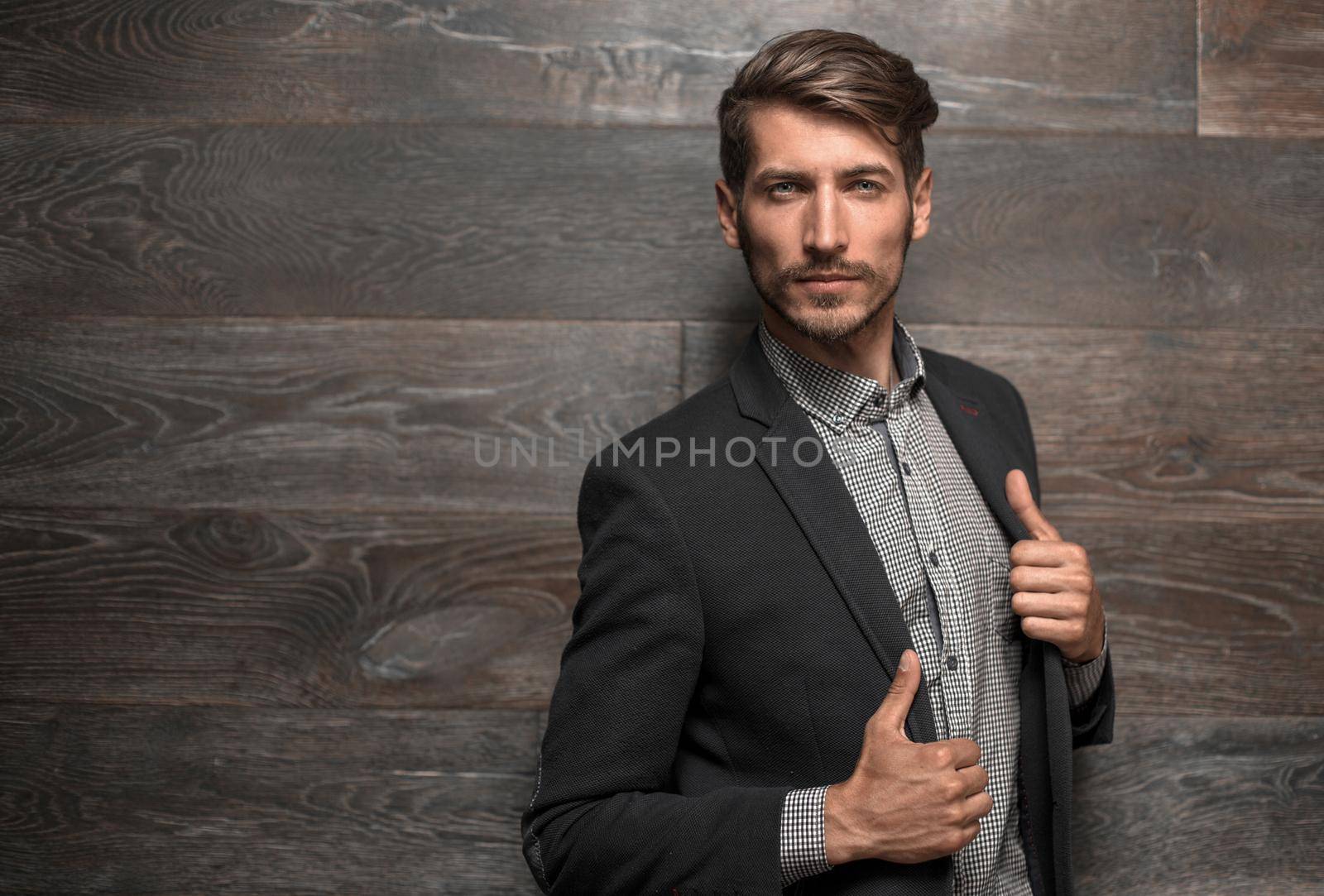 attractive man in black suit on dark background acting