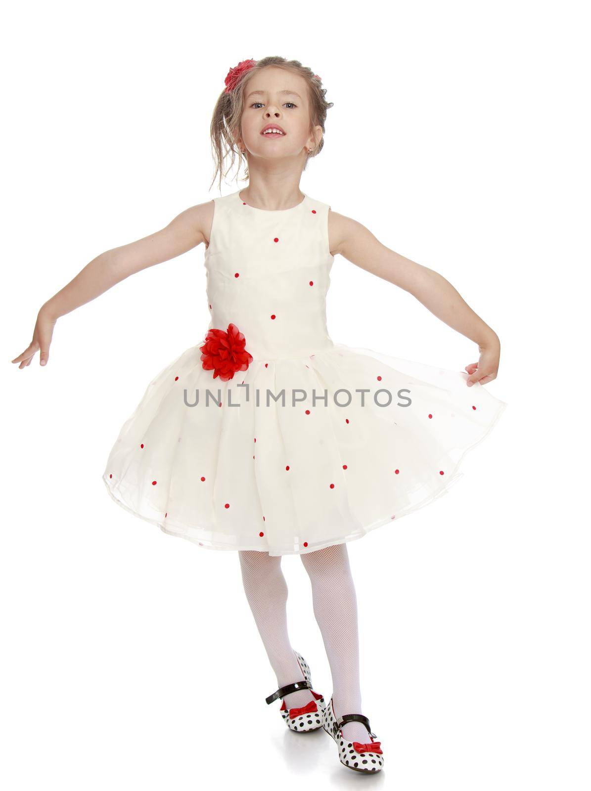 Delicate little Princess dressed in a white dress with a red flower at the waist . The girl moves in front of the camera waving - Isolated on white background