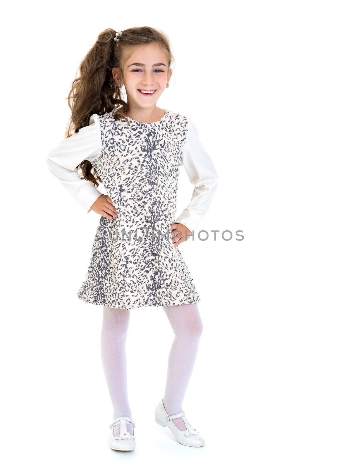 Beautiful little school girl with long silky hair. Studio portrait in full growth. Concept of style and fashion, happy people. Isolated on white background.