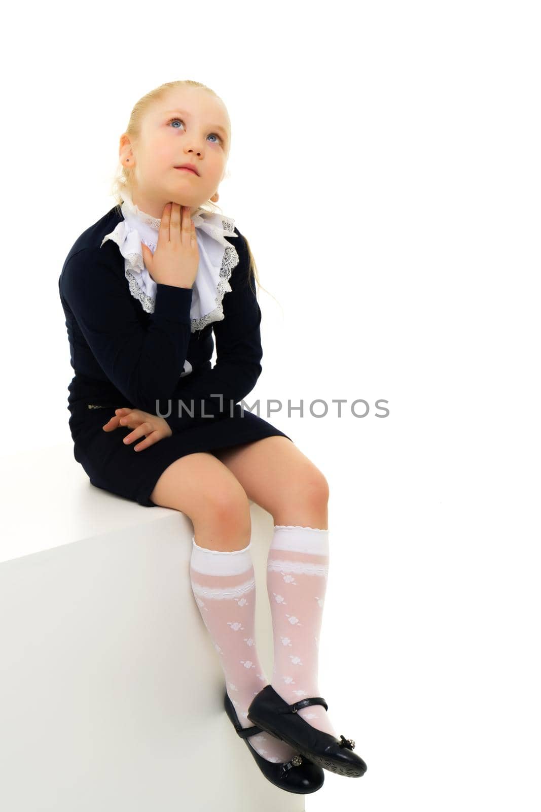 A nice little girl thinks. The concept of education and school, children's creativity. Isolated on white background.