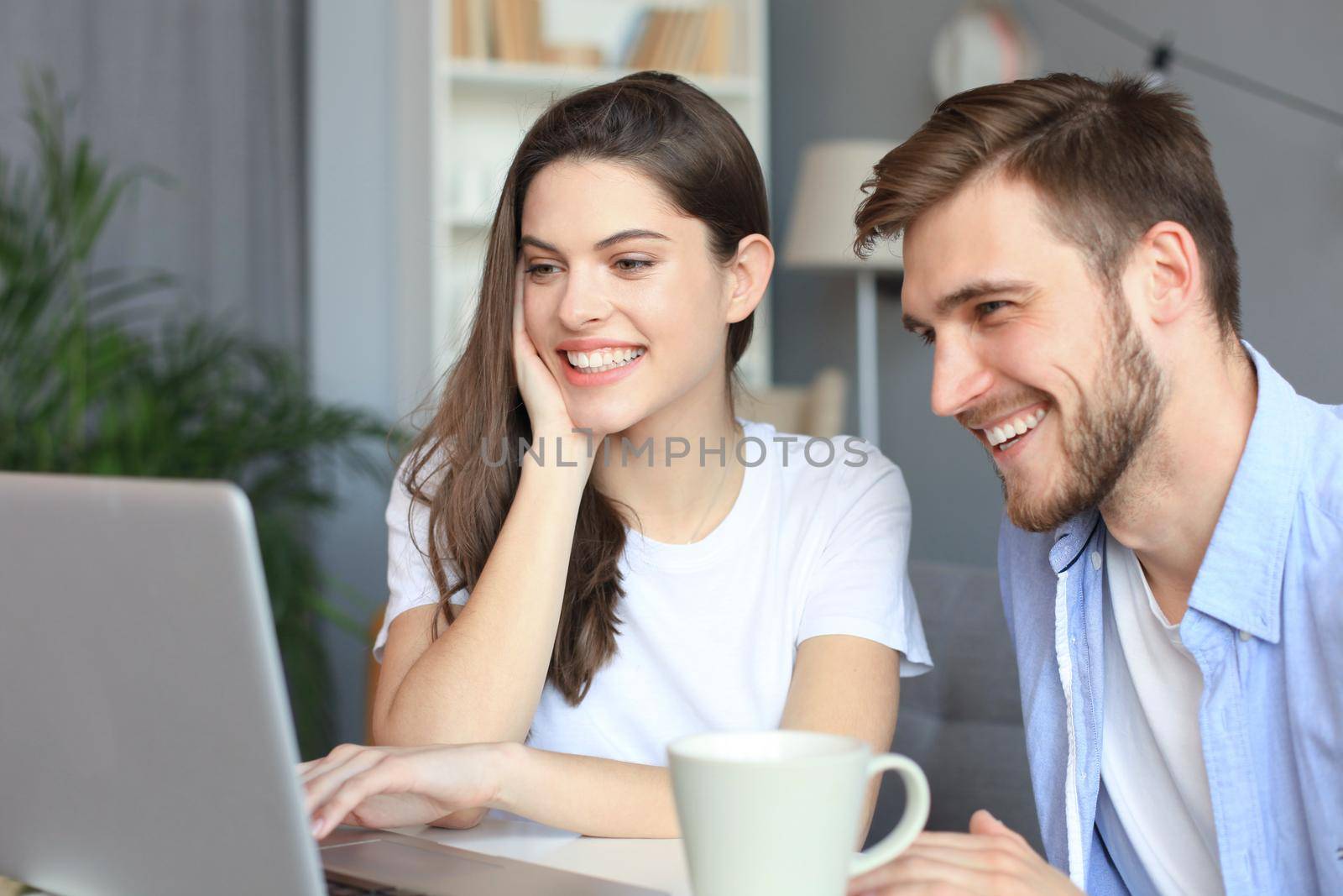 Couple pointing while working together on laptop