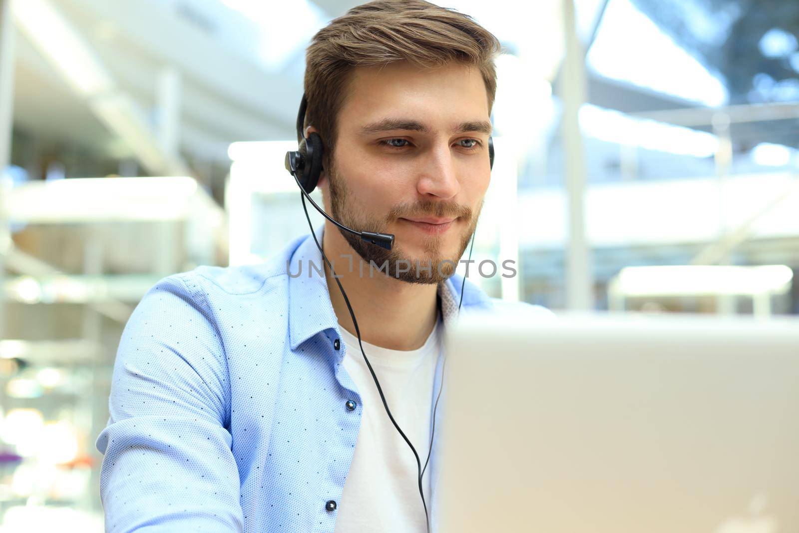 Happy young male customer support executive working in office