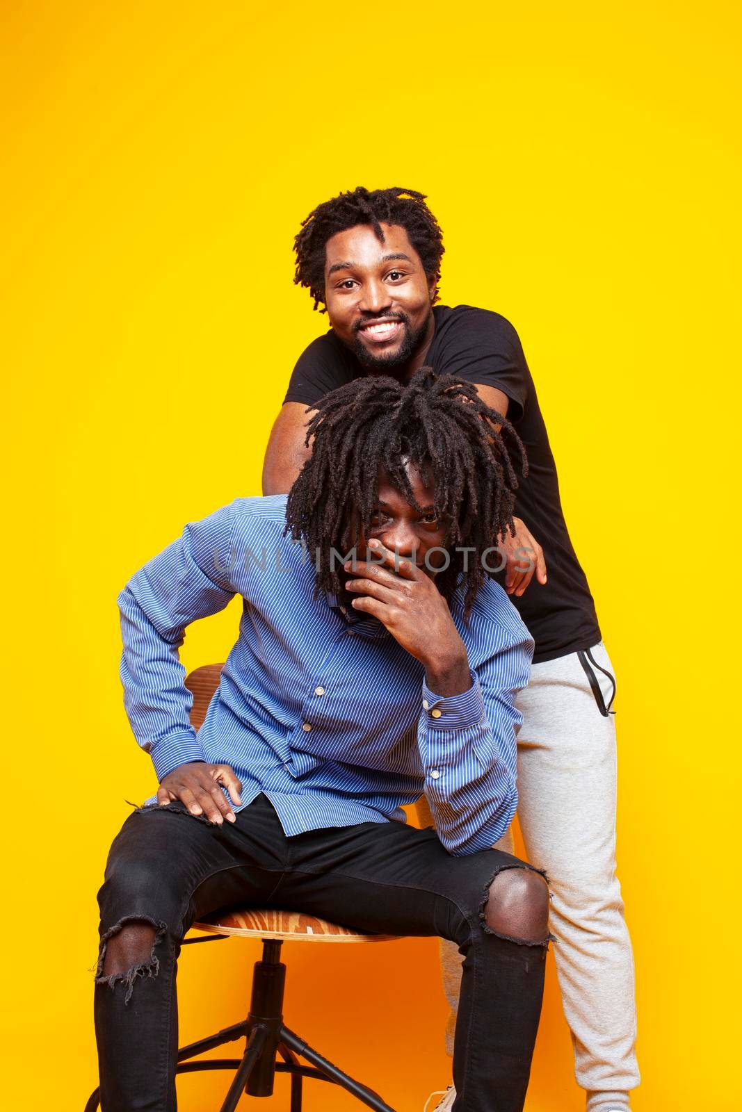 two african american guys posing cheerful together on yellow background, lifestyle people concept by JordanJ