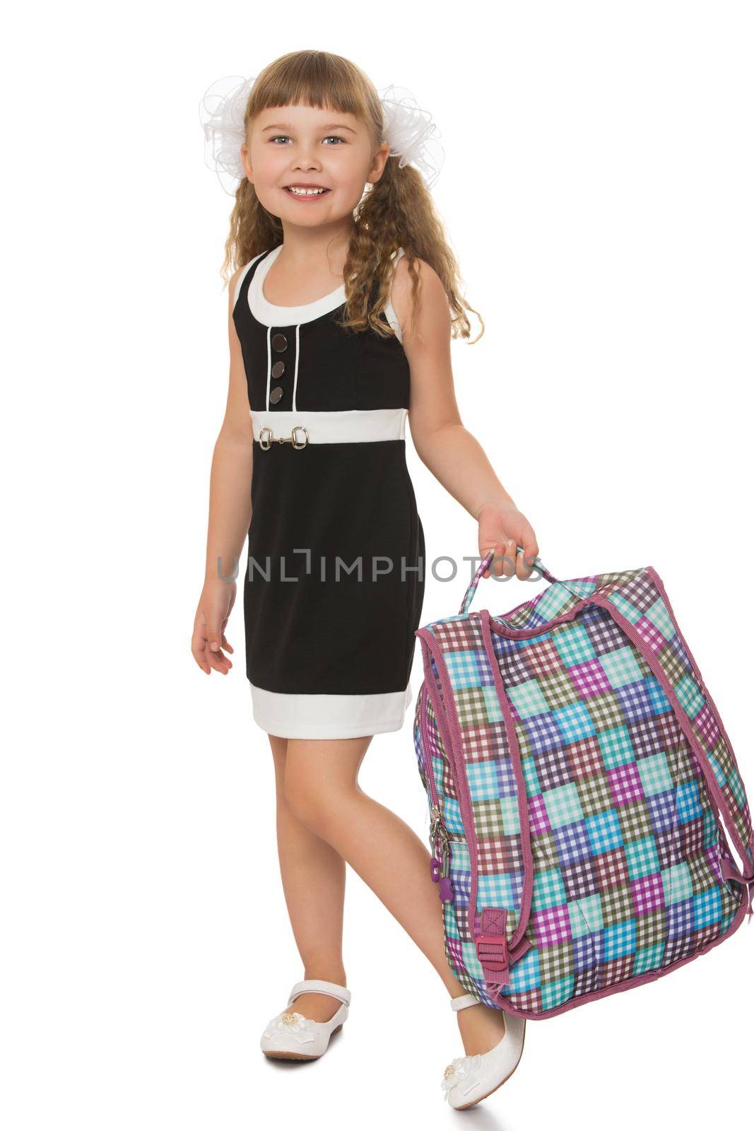 Laughing girl in the black school dress . The girl carries a satchel- Isolated on white background